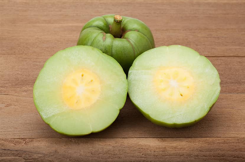 Garcinia cambogia entera y cortada por la mitad
